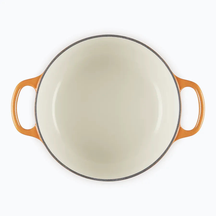 The casserole with the lid off, showing the pale sand coloured enamel interior