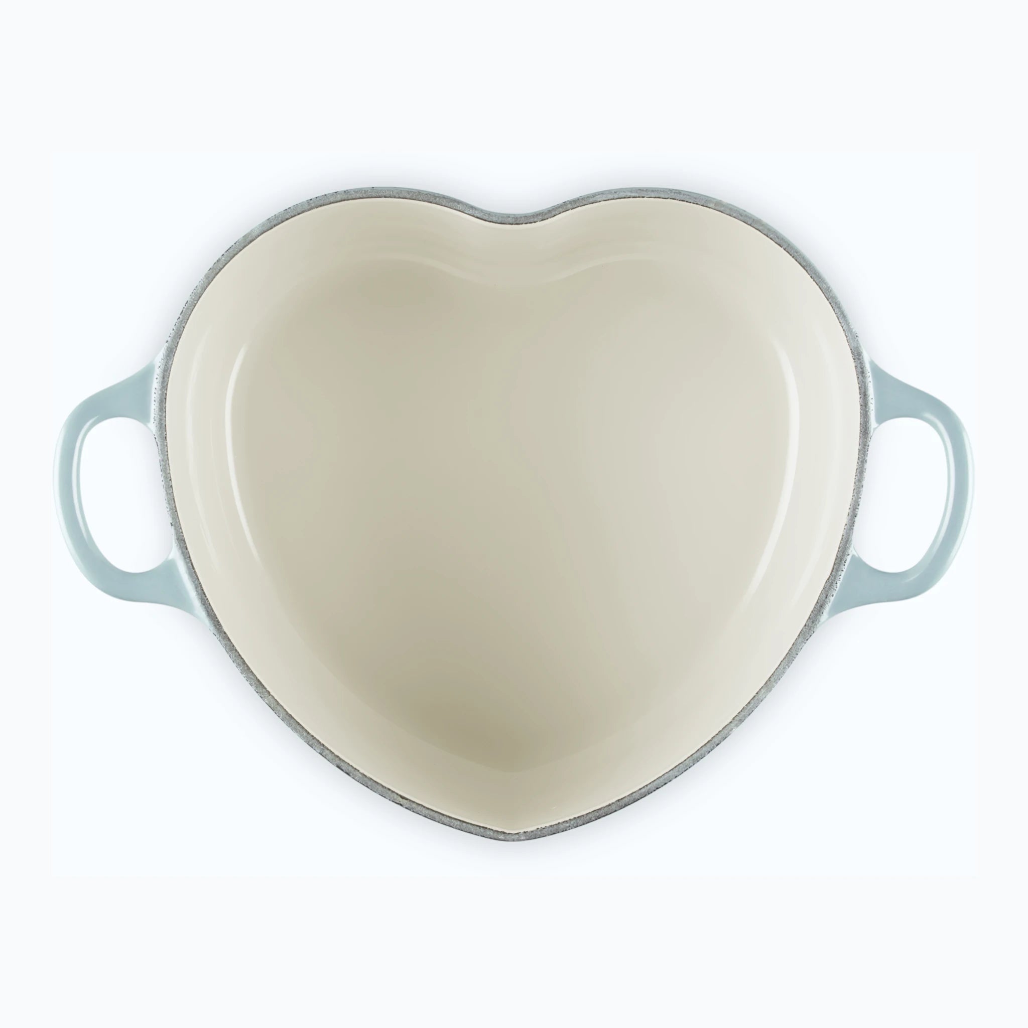 The heart casserole with the lid off, showing the heart-shaped cavity and pale cream enamel interior