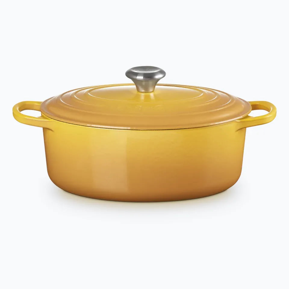 Cast iron oval casserole with the lid on, in nectar yellow
