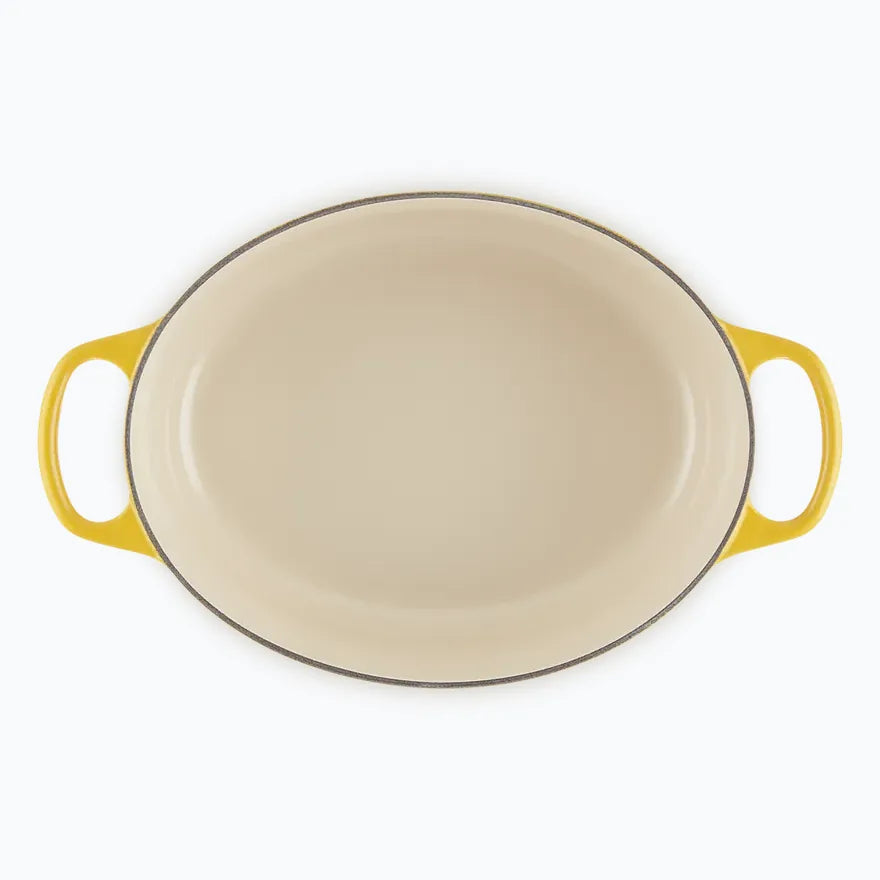 The oval casserole seen from above with the lid off, showing the pale enamel interior