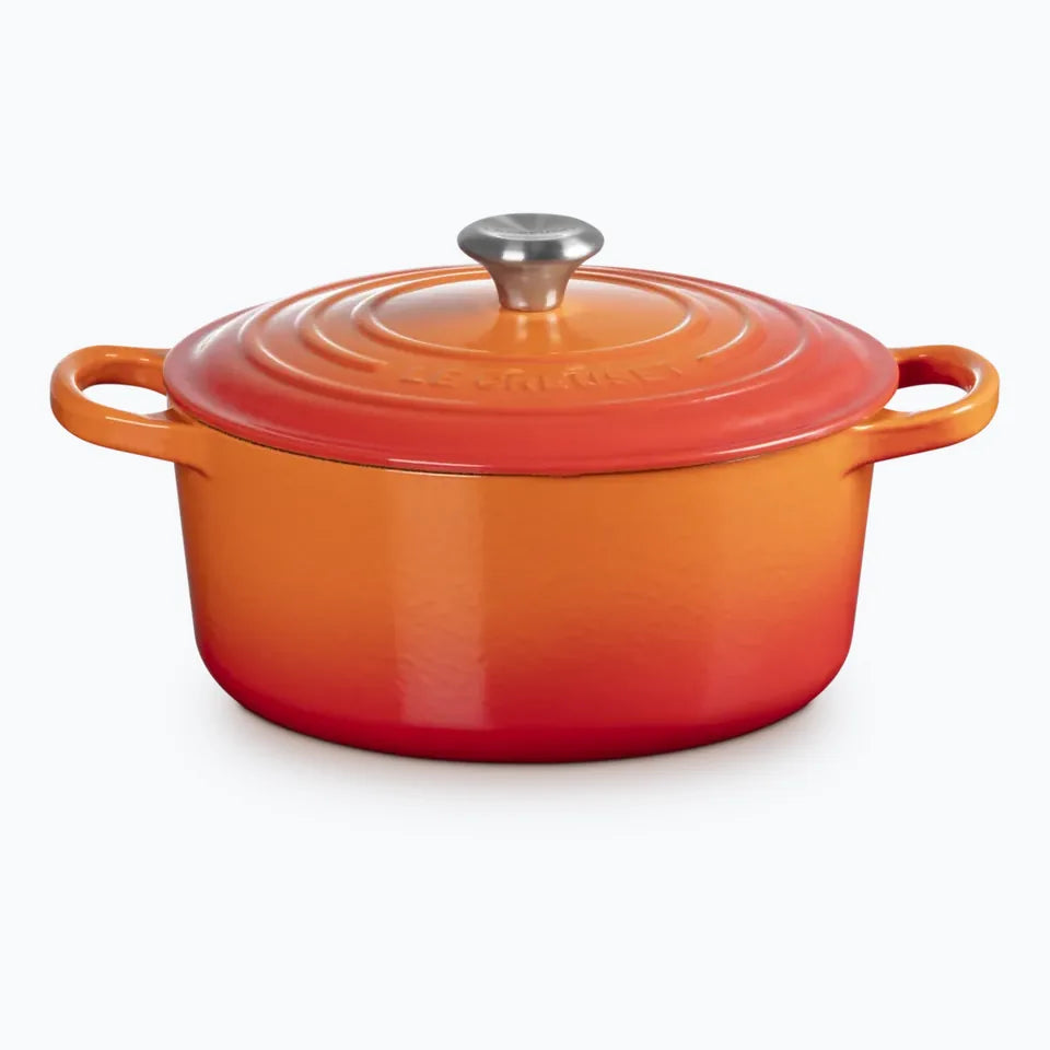 Cast iron round casserole with the lid on, in volcanic orange