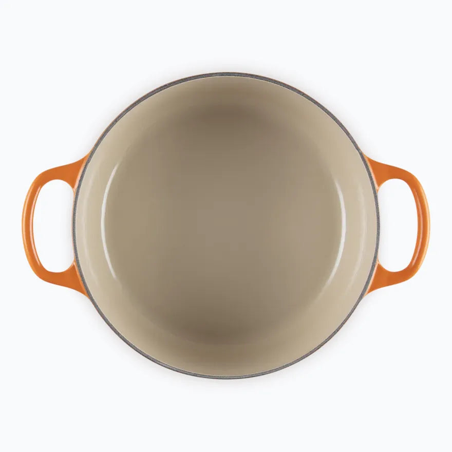 The casserole seen from above with the lid off, showing the pale sand coloured enamel interior